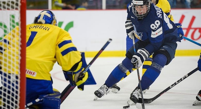 Finland defender Ronja Savolainen attacks the net defended by Sweden goaltender Sara Grahn and scores during a April 9, 2023 game at the women's world hockey championship in Brampton, Ont.