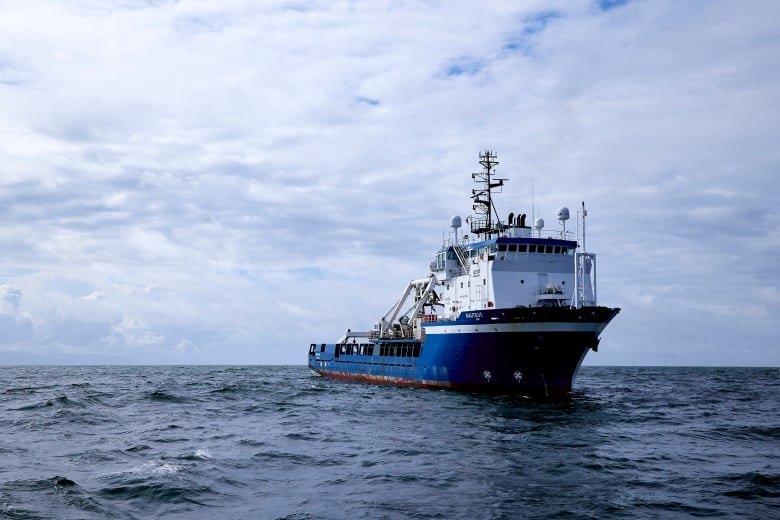 A large ship is seen sailing across the ocean.