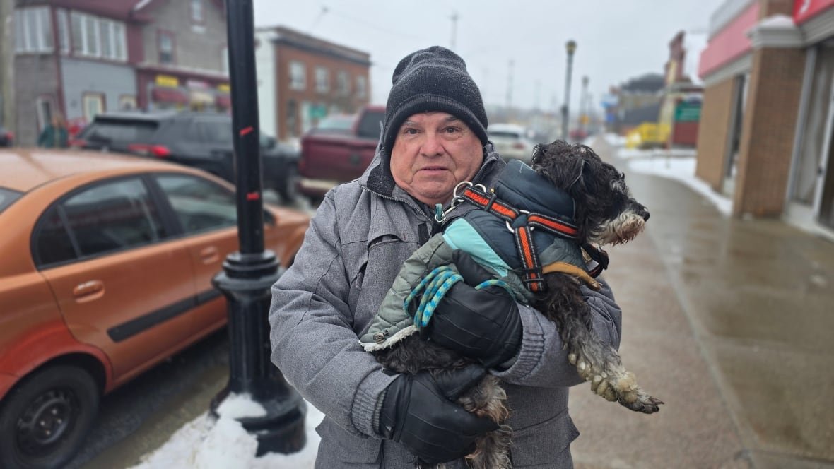 Donald Hunter with his dog, Watson, on the sidewalk.