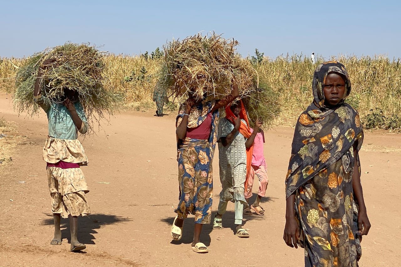 Young girls walking in a refugee camp in Sudan.