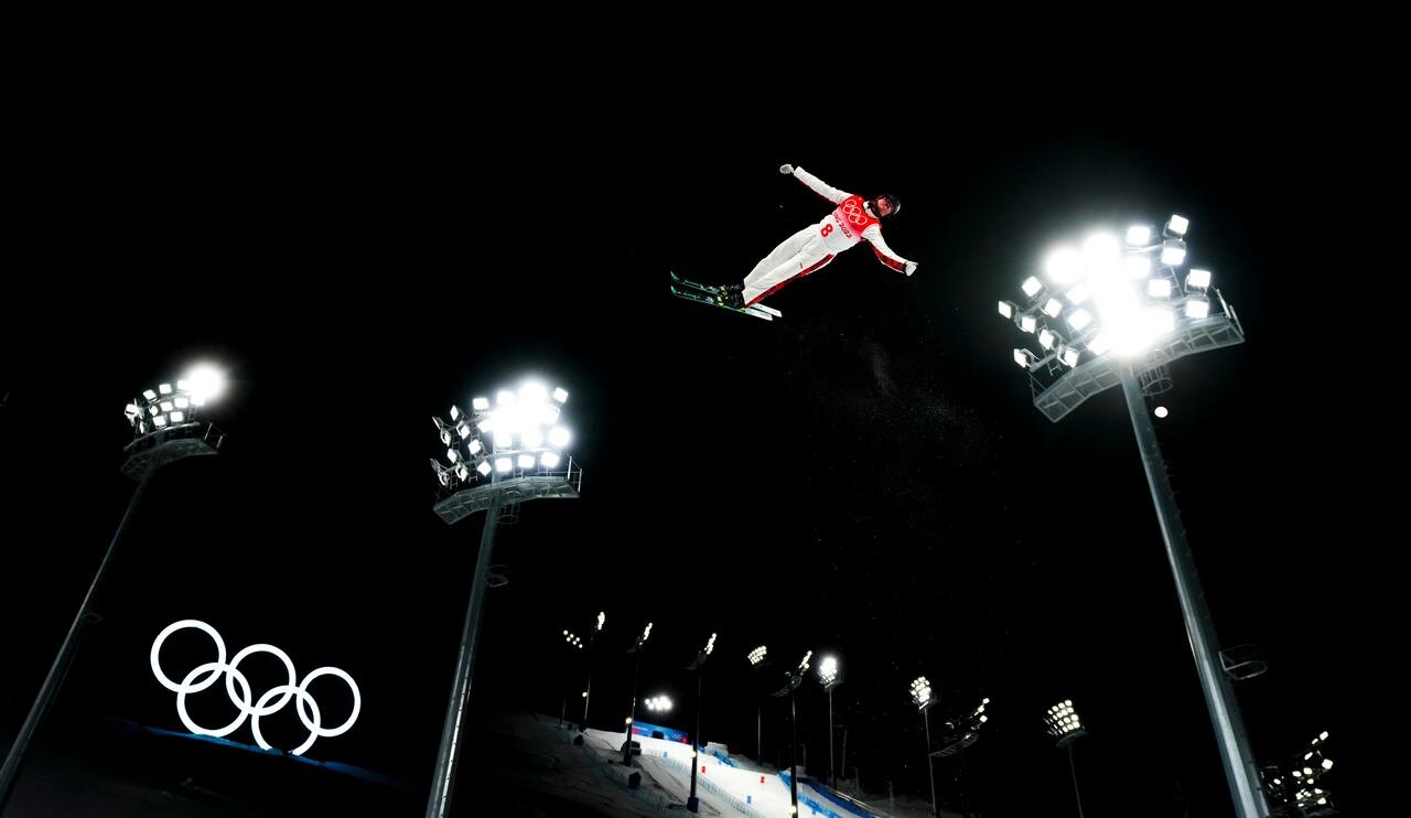 default-578 An aerials skier performs above the Olympic rings logo.