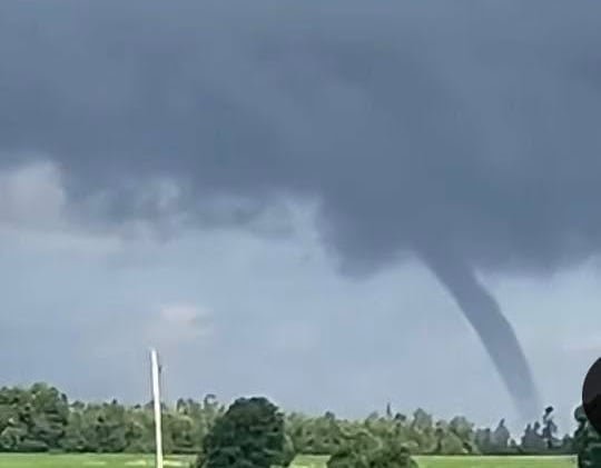 A tornado can be seen in the distance