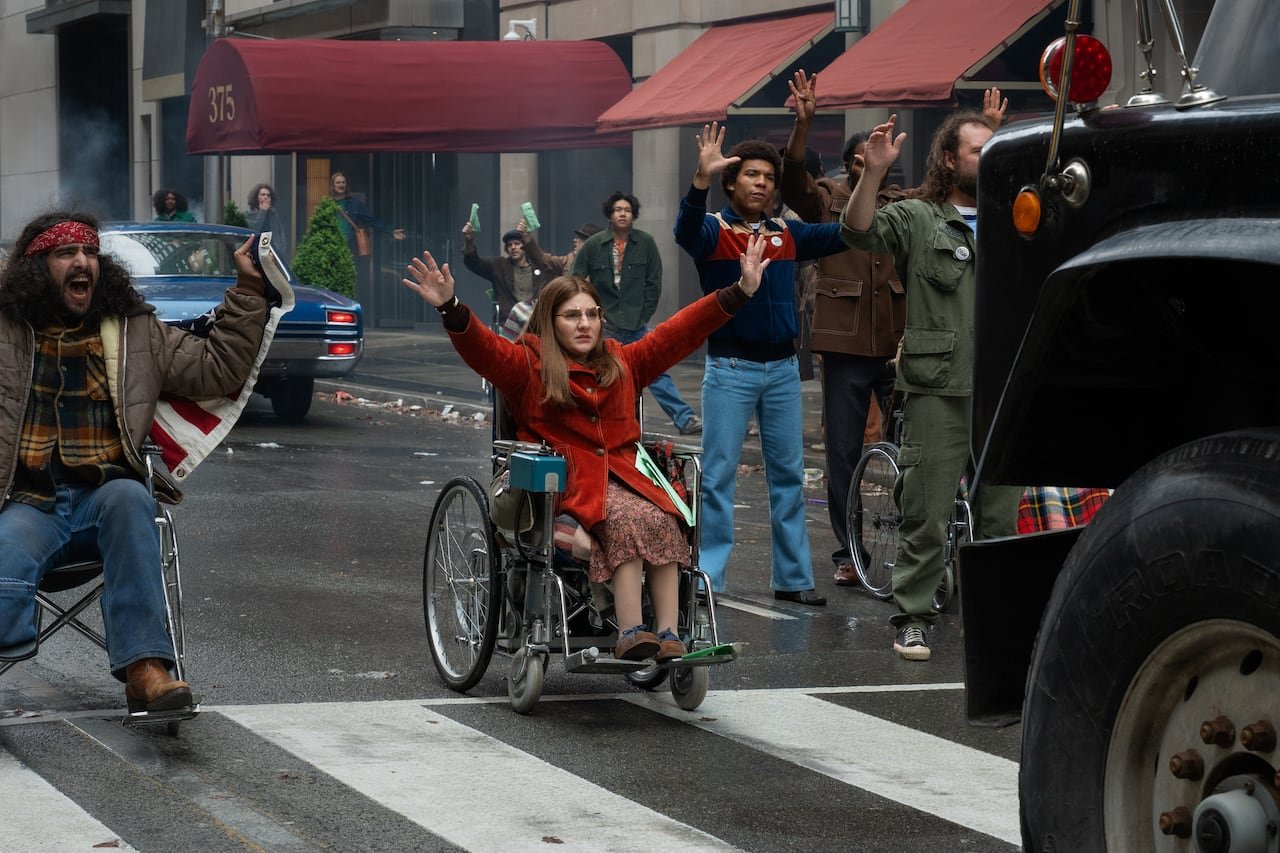 Woman in wheelchair in street.