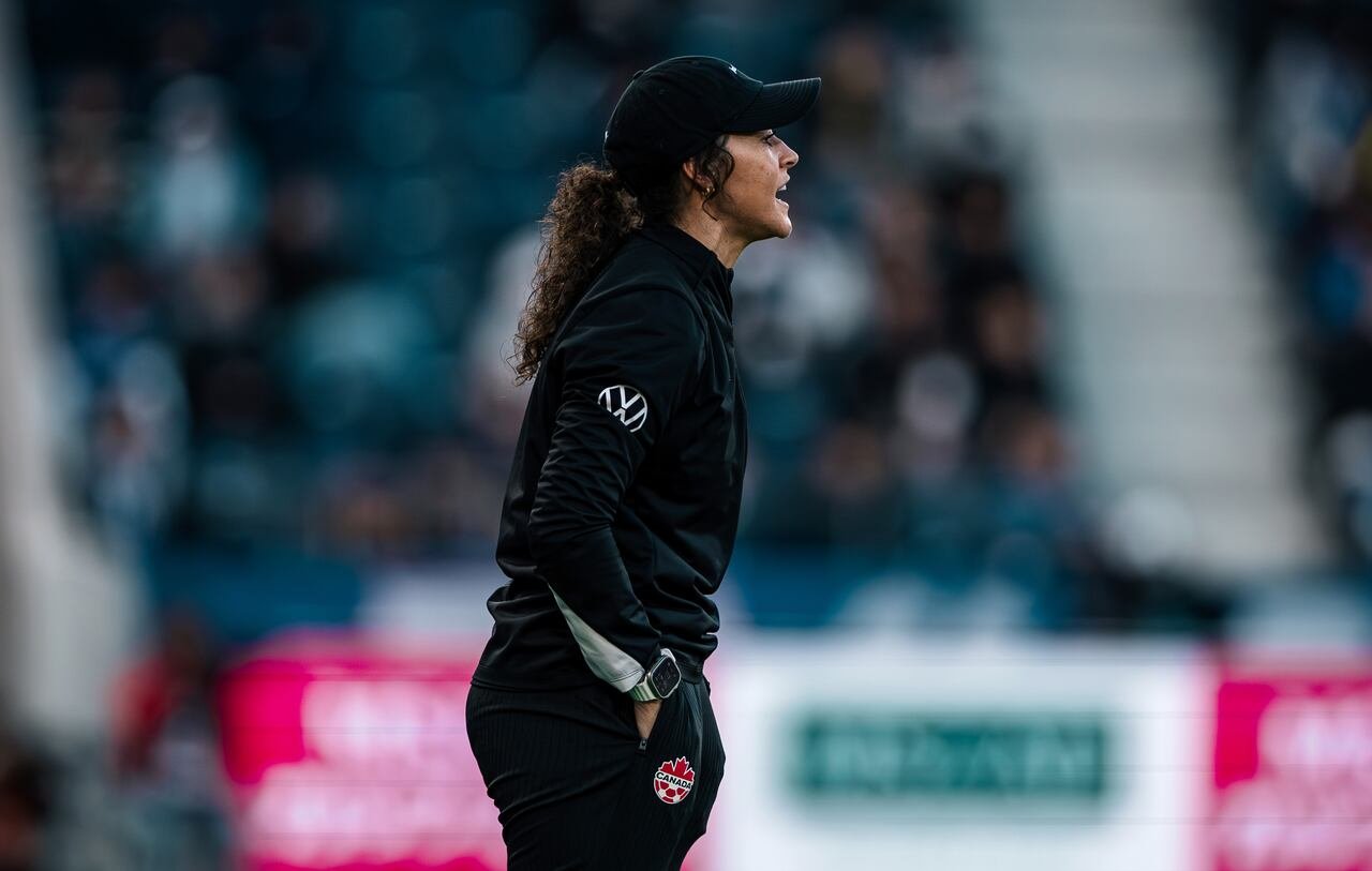 An assistant coach representing Canada shouting instructions on the sideline.